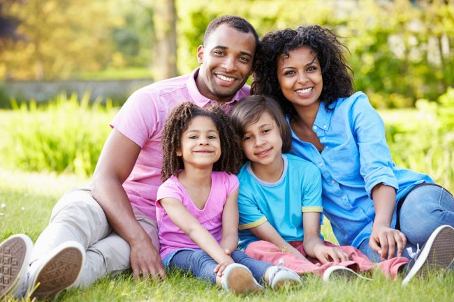 African American Family Sitting In Garden